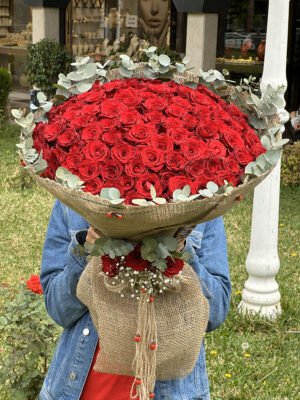 Adana 101 gül hasır paketleme, etrafı yeşil yapraklarla süslü doğal görünümlü kız isteme çiçeği.