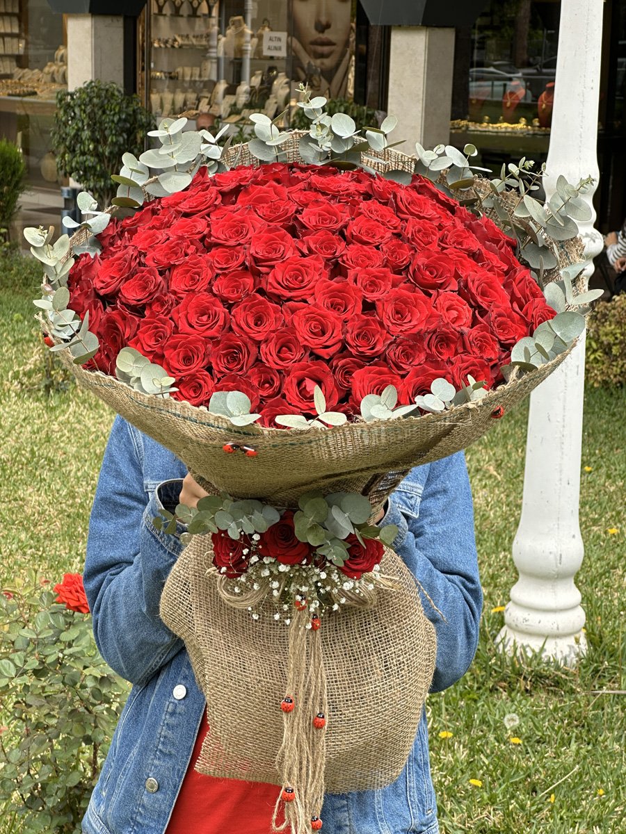 Adana 101 gül hasır paketleme, etrafı yeşil yapraklarla süslü doğal görünümlü kız isteme çiçeği.