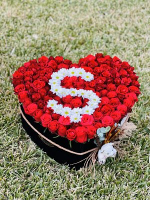 Adana kalp kutu çiçek, kırmızı güller arasında beyaz papatya ile isim yazılı hediye.