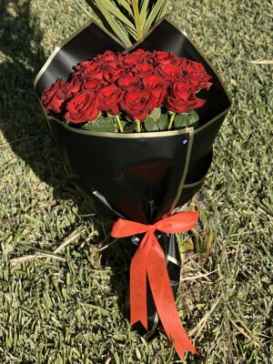 Adana 21 kırmızı gül buketi, kenarları altın yaldızlı lüks siyah kağıda sarılı, kırmızı kurdele ve nazar boncuğu detaylı aranjman