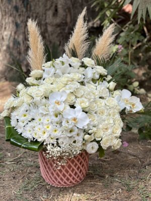 Adana beyaz casablanca aranjmanı, pembe renkli örme desenli saksıda taze beyaz güller, orkide dalları, krizantemler ve pampas otlarıyla hazırlanan lüks çiçek.