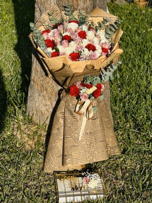 Adana kız isteme seti, gazete desenli kraft kağıda sarılı kırmızı, beyaz ve pembe güllerden oluşan dev buket ve önünde isim yazılı cam nişan gondolu.