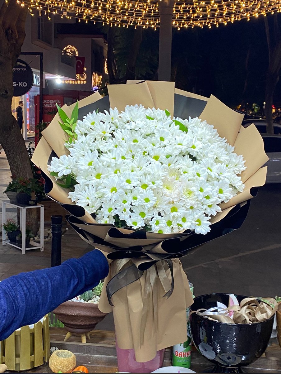 Adana dev papatya buketi, siyah ve kraft renkli çift katmanlı premium ambalaja sarılı kucak dolusu taze beyaz papatya aranjmanı.